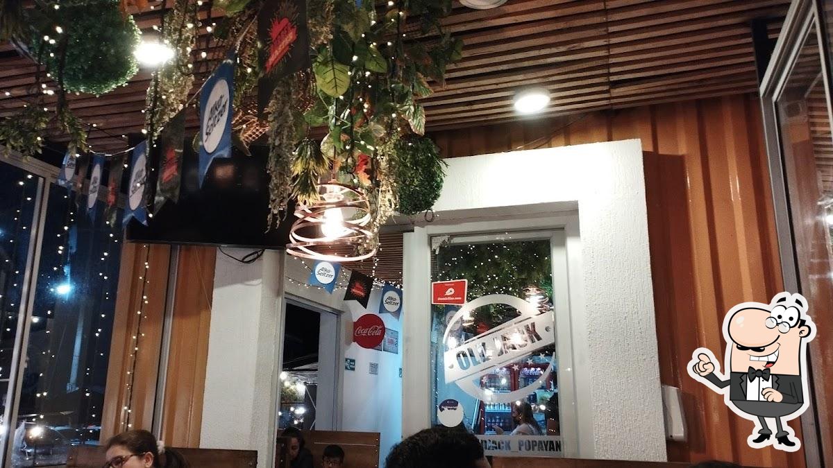 Interior acogedor de Old Jack con techo de madera, plantas y ambiente cálido